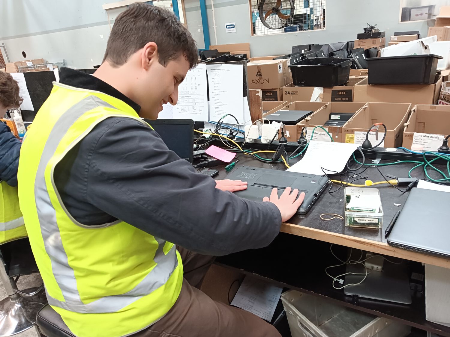 A volunteer checking a laptop at the build bench